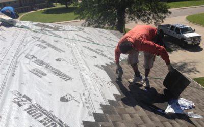 person on residential roof installing new shingles