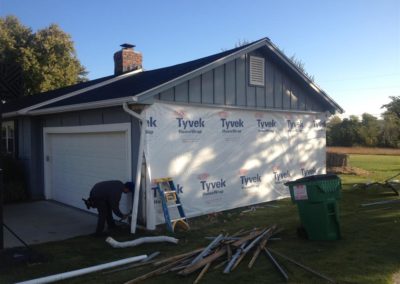 Image representing Gorilla Exteriors vinyl siding repair and installation services in Kansas City showcasing a man doing new siding work on the side of a garage.