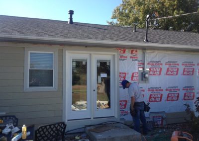 Image representing Gorilla Exteriors vinyl siding repair and installation services in Kansas City showcasing new siding work being done on the back of a ranch home.