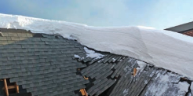What Cold Weather Does to Your Roof (And Why It Matters in Kansas City) 1 residential home with roof damage due to heavy snow build-up